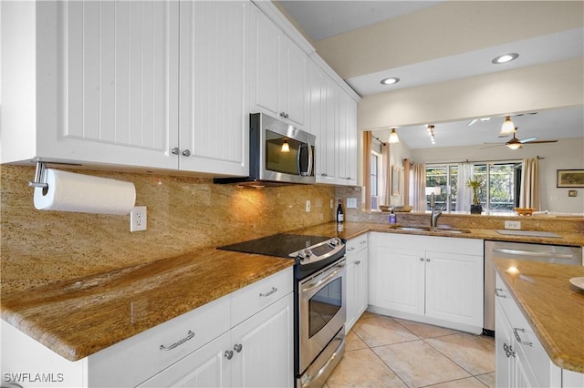 kitchen featuring appliances with stainless steel finishes, a sink, ceiling fan, tasteful backsplash, and white cabinets