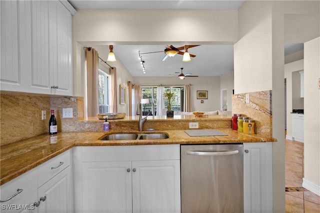 kitchen featuring dishwasher, a sink, light stone counters, decorative backsplash, and a ceiling fan