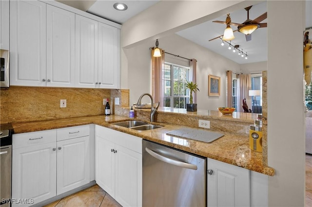 kitchen featuring stainless steel appliances, a sink, a ceiling fan, light stone countertops, and white cabinets