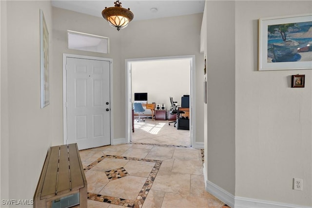 entryway with baseboards and inlaid floor details