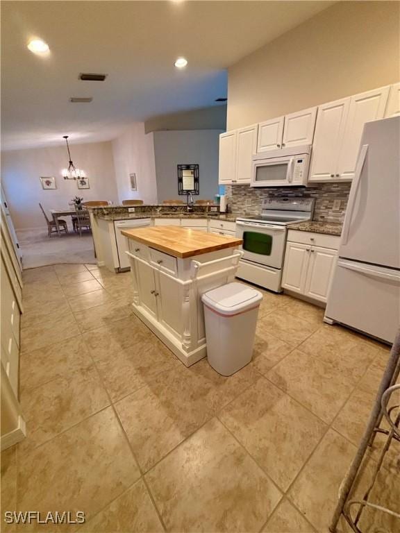 kitchen featuring pendant lighting, wood counters, a center island, white appliances, and kitchen peninsula