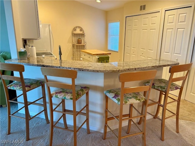 kitchen featuring light colored carpet and kitchen peninsula