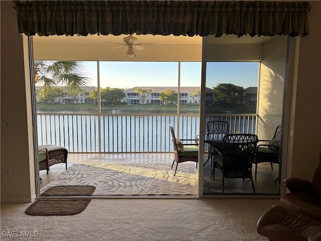 sunroom featuring a water view and ceiling fan