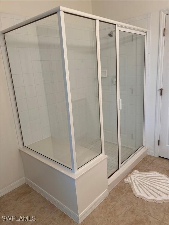 bathroom featuring tile patterned flooring and a shower with shower door