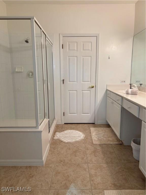 bathroom with tile patterned flooring, vanity, and a shower with door