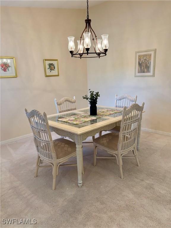 dining room with a chandelier and light carpet