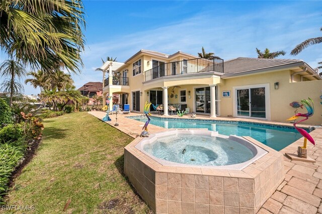 view of pool with an in ground hot tub, a patio, and a lawn