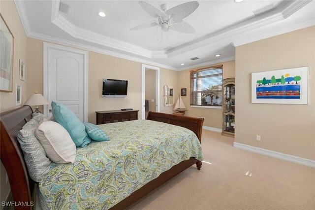 carpeted bedroom featuring a tray ceiling, ceiling fan, and crown molding