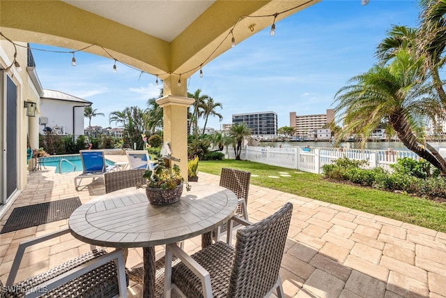 view of patio featuring a fenced in pool and a water view