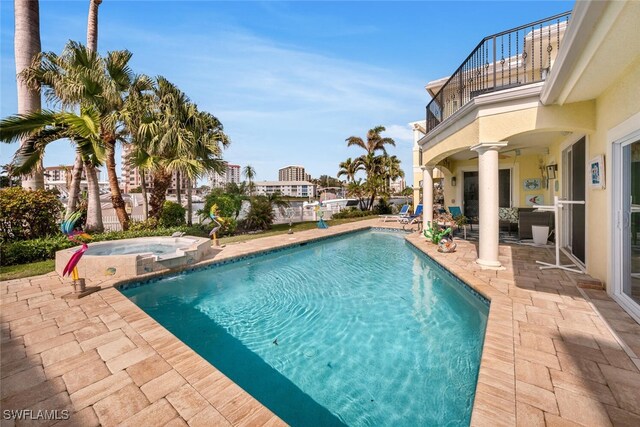 view of swimming pool featuring a patio area and an in ground hot tub