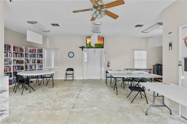 dining area with ceiling fan and concrete flooring