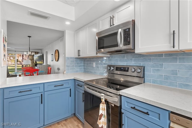 kitchen featuring decorative backsplash, white cabinetry, blue cabinetry, and appliances with stainless steel finishes