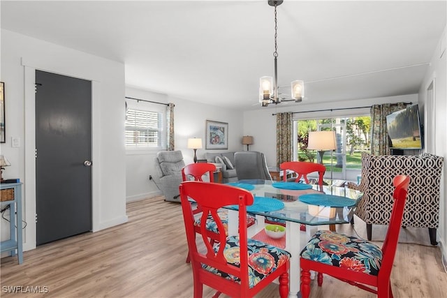 dining area with a notable chandelier, light hardwood / wood-style floors, and a wealth of natural light