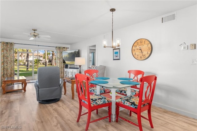 dining area featuring ceiling fan with notable chandelier and light hardwood / wood-style floors