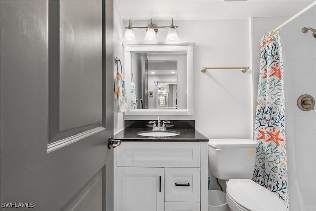 bathroom featuring vanity, toilet, and walk in shower