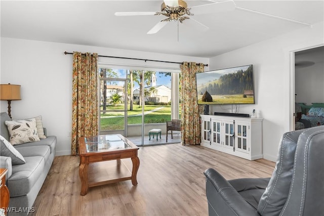 living room with light hardwood / wood-style floors and ceiling fan