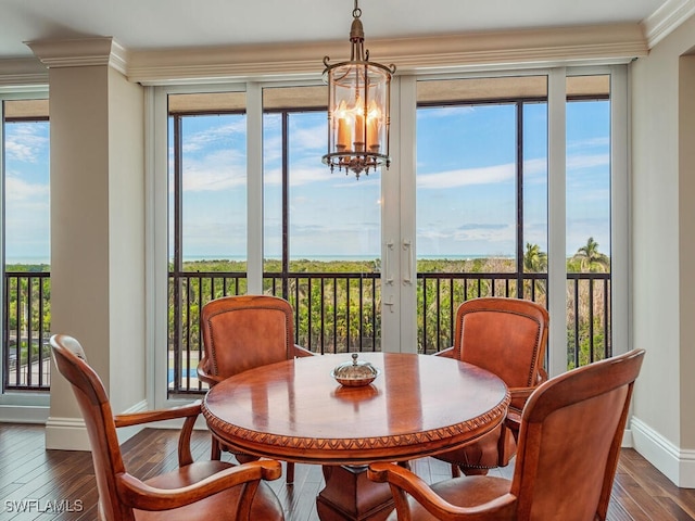 dining room featuring crown molding, wood-type flooring, and an inviting chandelier