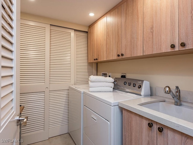 laundry room with washer and clothes dryer, cabinets, and sink