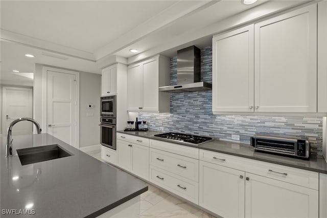 kitchen featuring sink, white cabinetry, stainless steel appliances, tasteful backsplash, and wall chimney exhaust hood