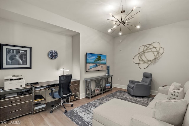 home office with a chandelier and light hardwood / wood-style flooring