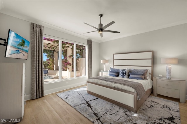 bedroom with ornamental molding, ceiling fan, and light hardwood / wood-style flooring