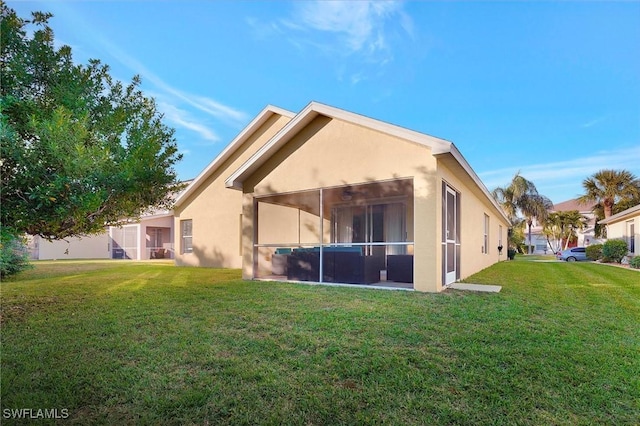 back of property with a lawn and a sunroom