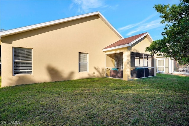 rear view of property featuring a yard and a sunroom