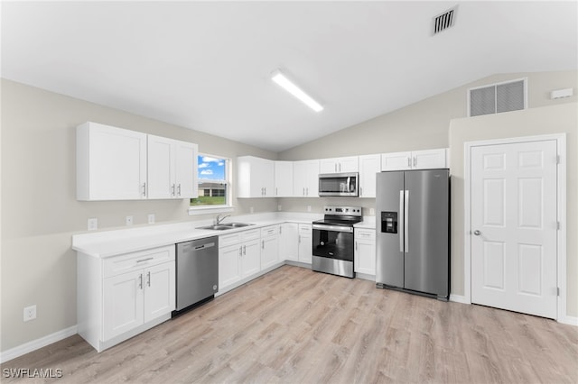 kitchen with appliances with stainless steel finishes, light wood-type flooring, sink, white cabinets, and lofted ceiling