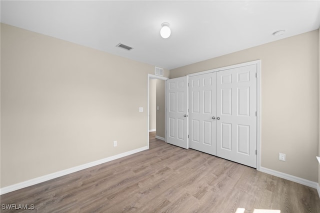 unfurnished bedroom with a closet and light wood-type flooring