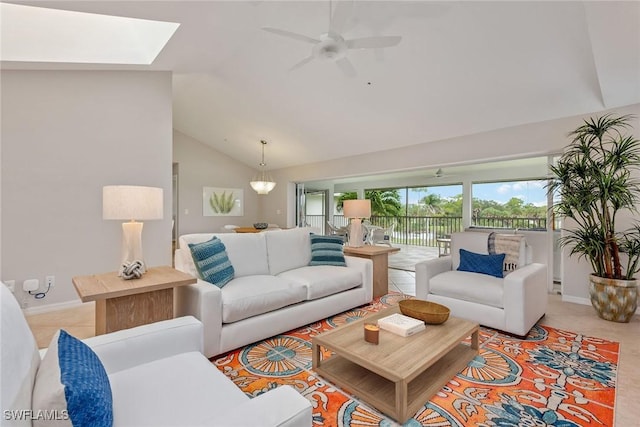 tiled living room with vaulted ceiling with skylight and ceiling fan