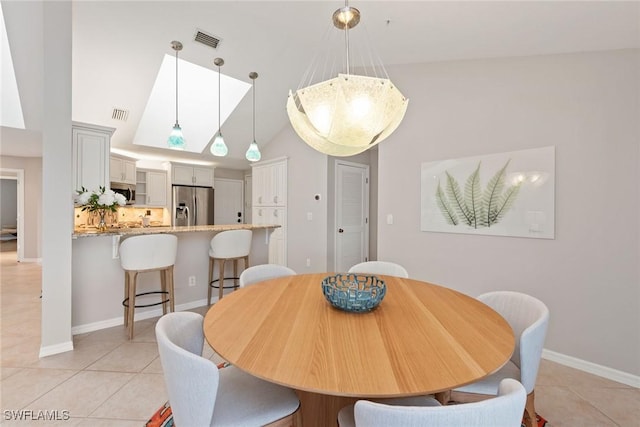 dining area featuring vaulted ceiling and light tile patterned flooring