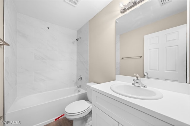 full bathroom featuring tiled shower / bath, vanity, and toilet