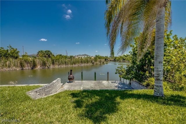 view of dock featuring a lawn and a water view