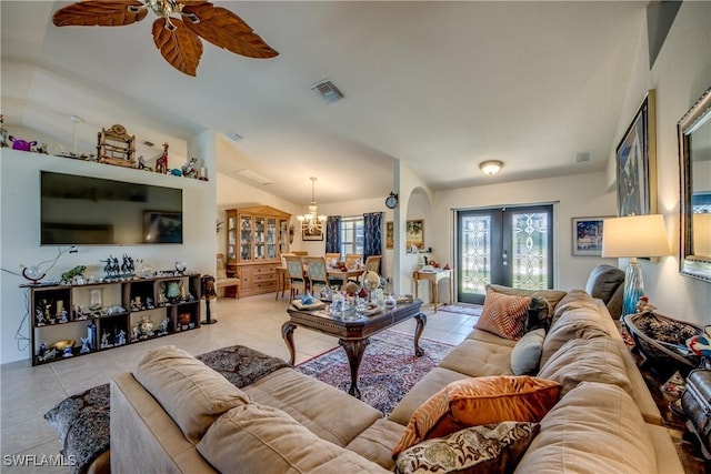 living room with ceiling fan with notable chandelier, light tile patterned floors, and french doors