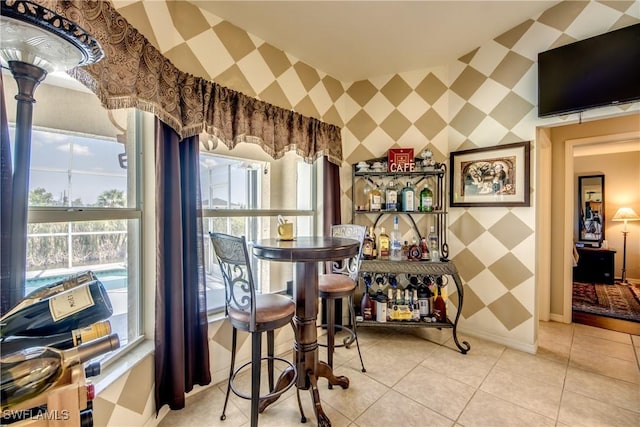 interior space featuring bar area, light tile patterned flooring, and a healthy amount of sunlight