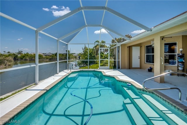 view of pool featuring glass enclosure, a water view, and a patio