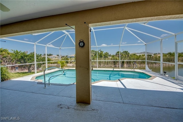 view of swimming pool with a patio, a water view, and a lanai