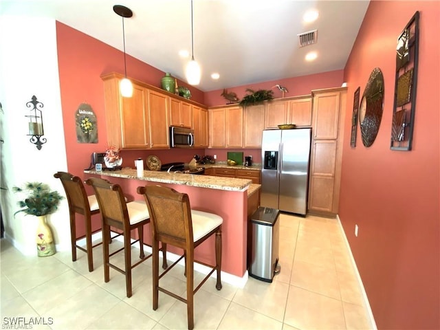 kitchen featuring light stone countertops, pendant lighting, appliances with stainless steel finishes, kitchen peninsula, and light tile patterned flooring