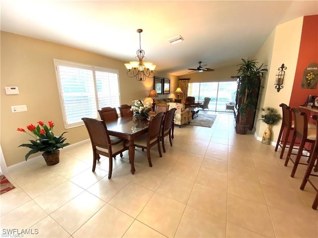 dining space with ceiling fan with notable chandelier and light tile patterned floors