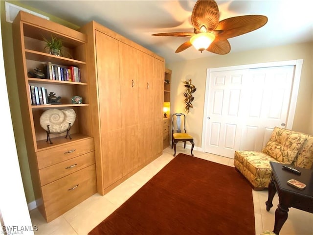 sitting room with ceiling fan and light tile patterned flooring