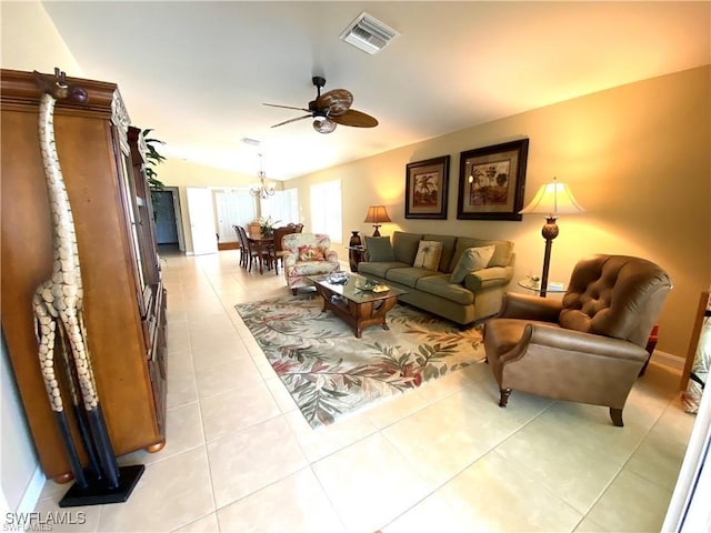 tiled living room with lofted ceiling and ceiling fan with notable chandelier