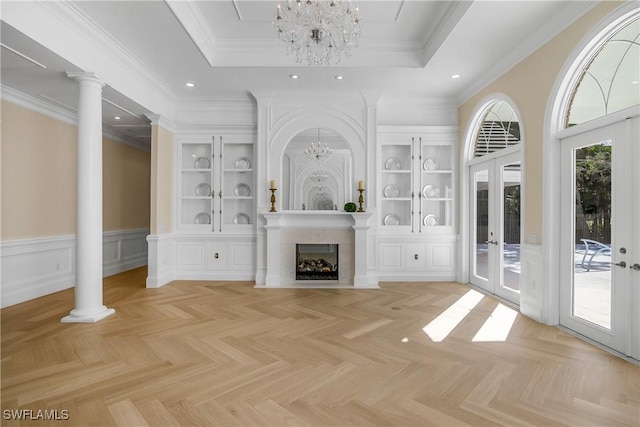 unfurnished living room featuring french doors, light parquet floors, a raised ceiling, and a notable chandelier