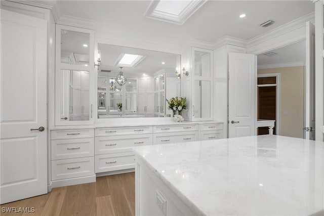 bathroom featuring wood-type flooring, a skylight, and crown molding