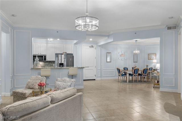 tiled living room featuring crown molding and a notable chandelier