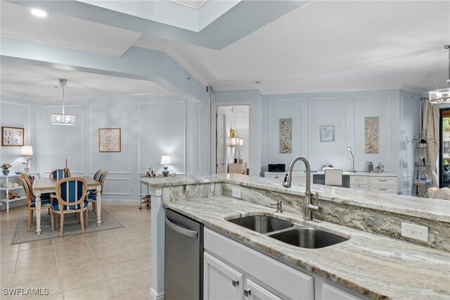 kitchen featuring crown molding, sink, hanging light fixtures, stainless steel dishwasher, and white cabinetry