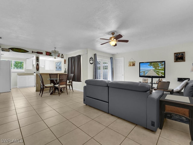 tiled living room with a textured ceiling and ceiling fan