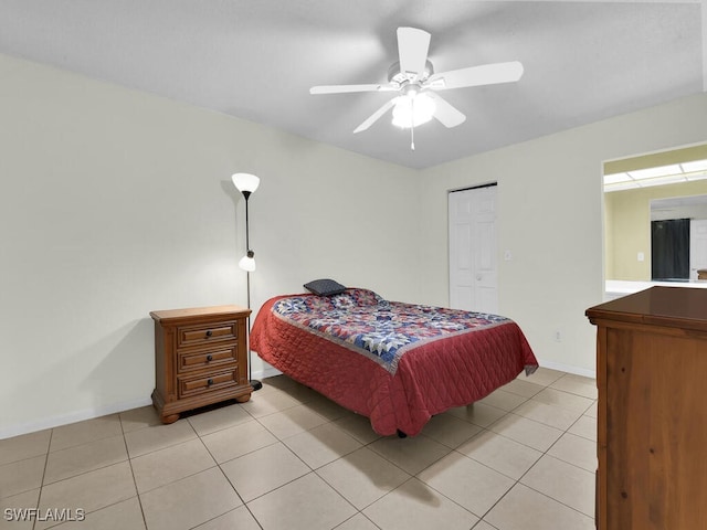 bedroom featuring ceiling fan, light tile patterned flooring, and a closet