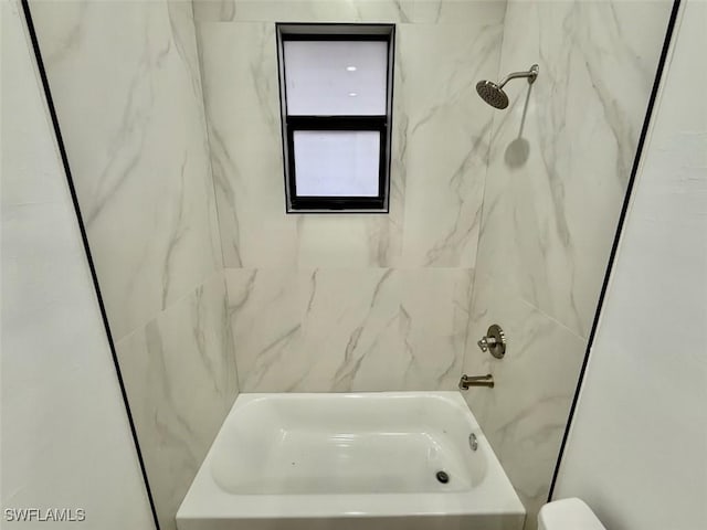 bathroom with toilet and tiled shower / bath