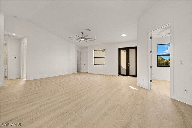 unfurnished living room with ceiling fan, vaulted ceiling, french doors, and light wood-type flooring