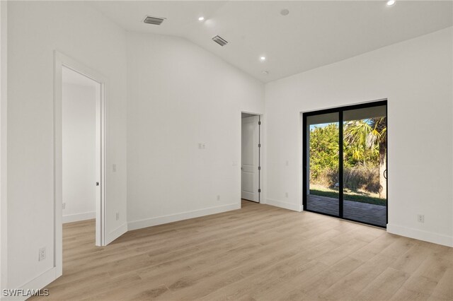 empty room with light wood-type flooring and lofted ceiling